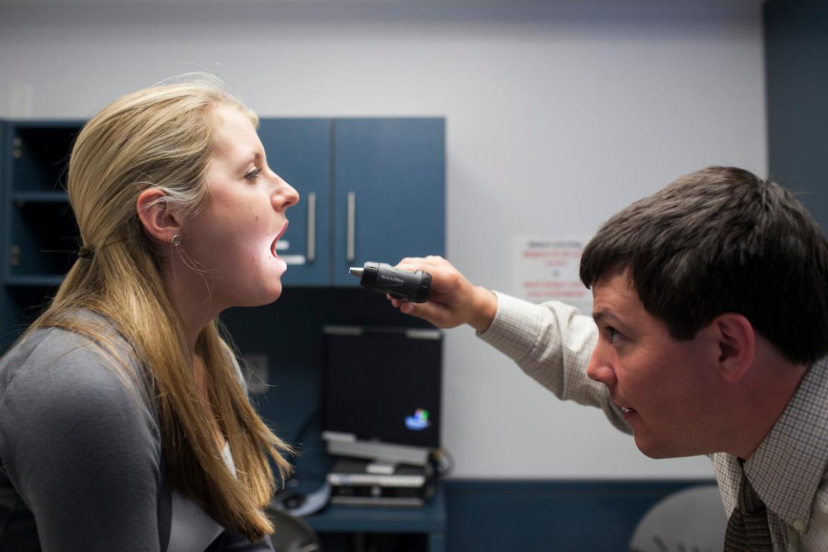 Tufts PA student checking patient's throat