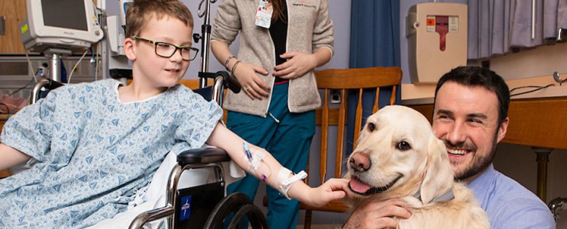 Patient with Tufts students petting a dog