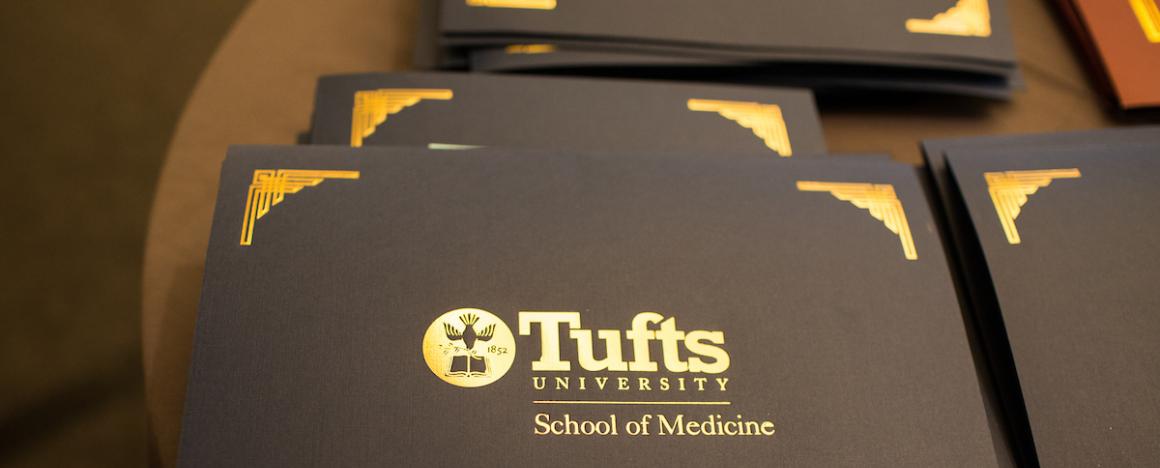Gilded folder with "Tufts University School of Medicine" written on it