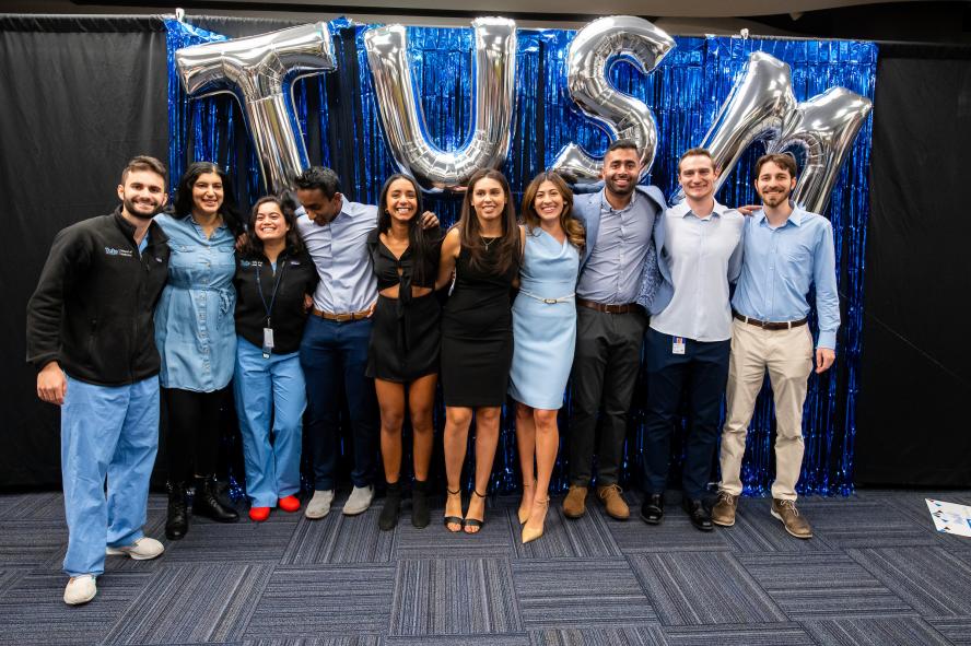 Group of MD students posing in front of balloons that spell TUSM