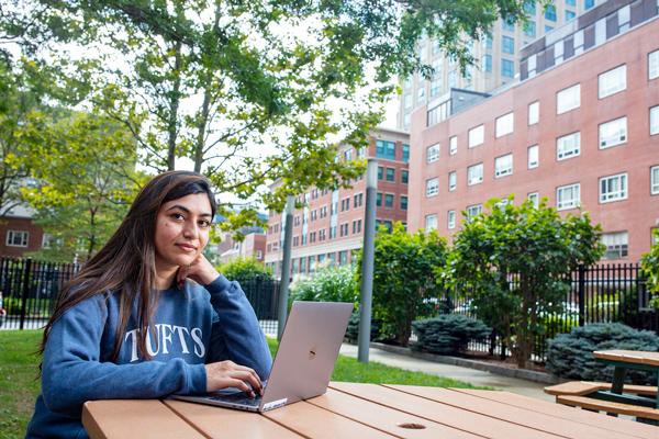 Tufts student sitting outside while on laptop