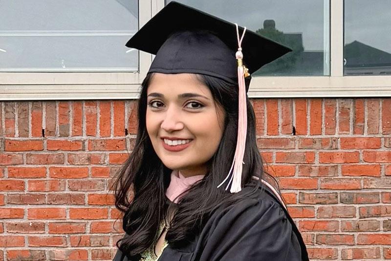 Headshot image of Zara in her graduation cap and gown