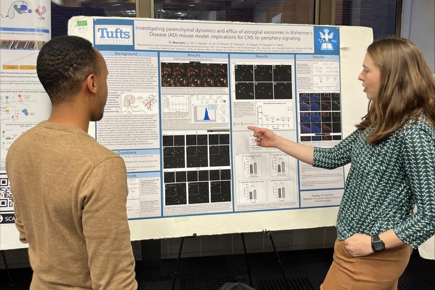 A student at the Charlton Poster competition explaining her research to another student.