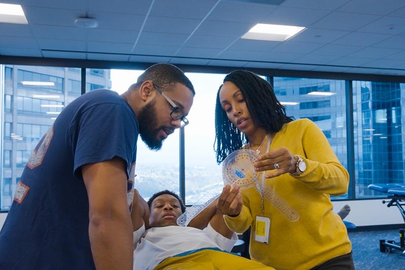 DPT students practice clinical skills lab and faculty member explains material