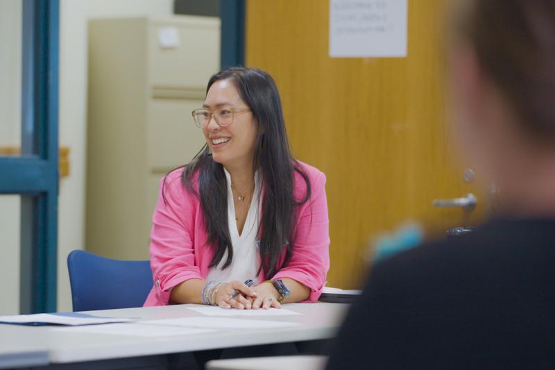 Tufts MPH program director sitting and talking in class