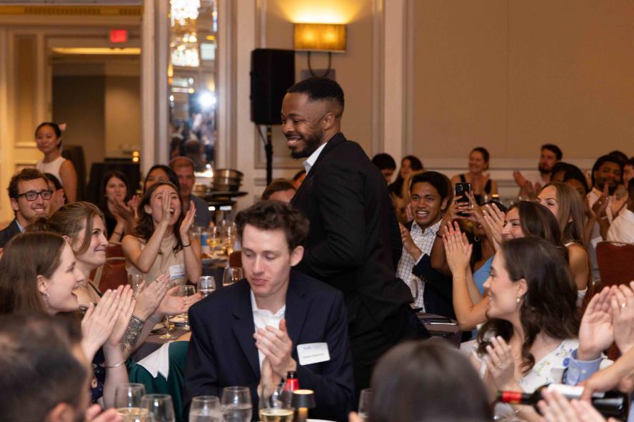 Students cheering as a classmate passes by to accept an award.