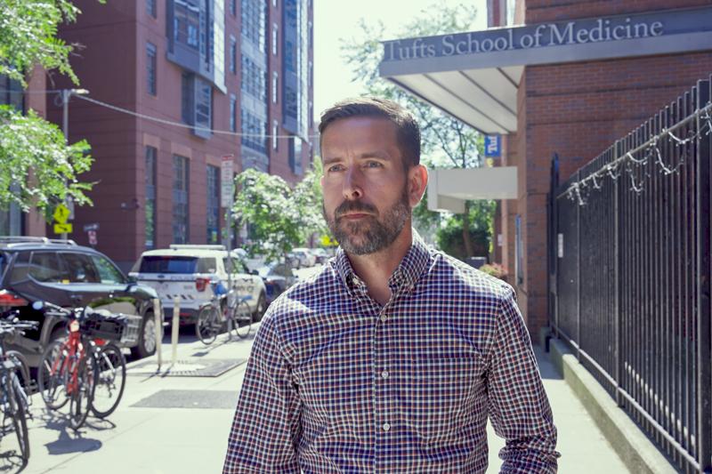 Jon Gass walks on Tufts Boston campus.