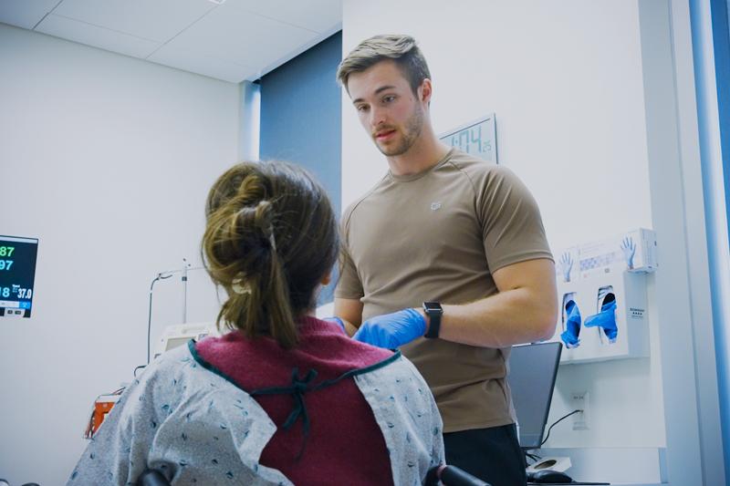 Noah Leaf speaks with patient in clinical setting
