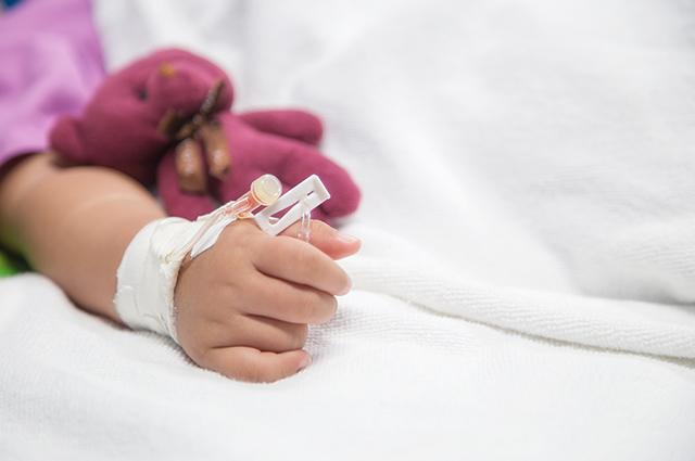 Infant surgery patient with tube attached to arm