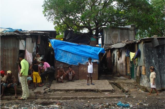 People outside of slum housing