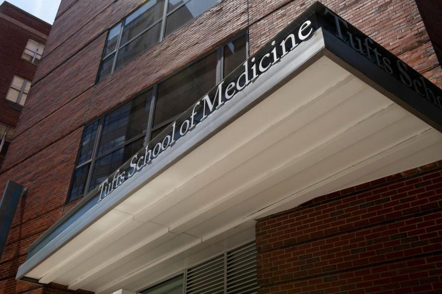 A School of Medicine sign on a brick building in Boston