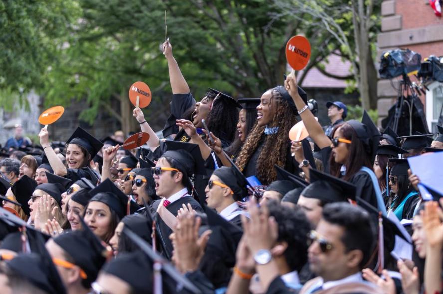 A crowd of graduates of the Fletcher School cheer