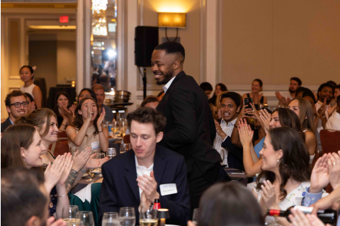 Students cheering as a classmate passes by to accept an award.