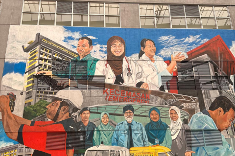 A mural on an exterior wall of the University of Malaya Medical Centre, showcasing health care workers and other familiar scenes at the hospital.