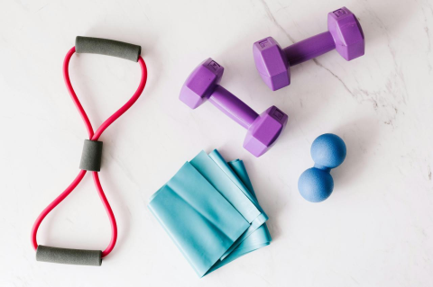 Workout equipment including light-weight dumbbells, rubber bands, and balls.